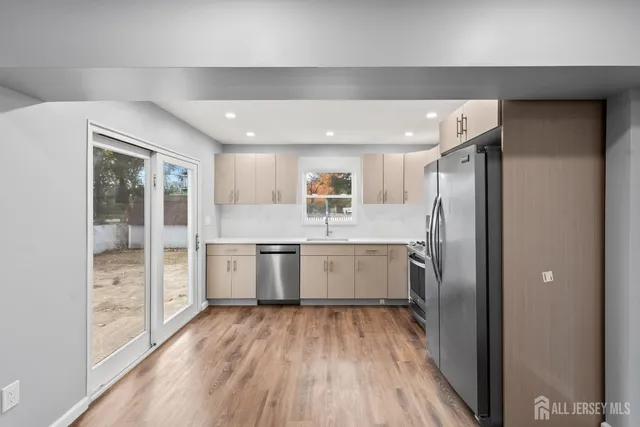 a large kitchen with a lot of counter space and wooden floor
