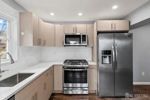 a kitchen with granite countertop a refrigerator and a sink