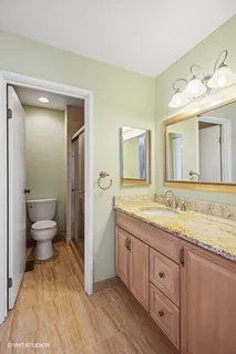 a bathroom with a granite countertop sink mirror and toilet