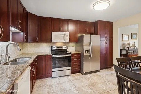 a kitchen with granite countertop stainless steel appliances and wooden cabinets