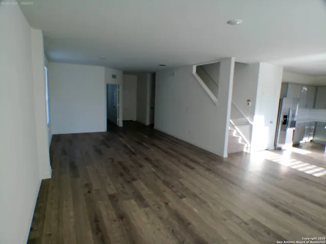 a view of a livingroom with wooden floor and staircase