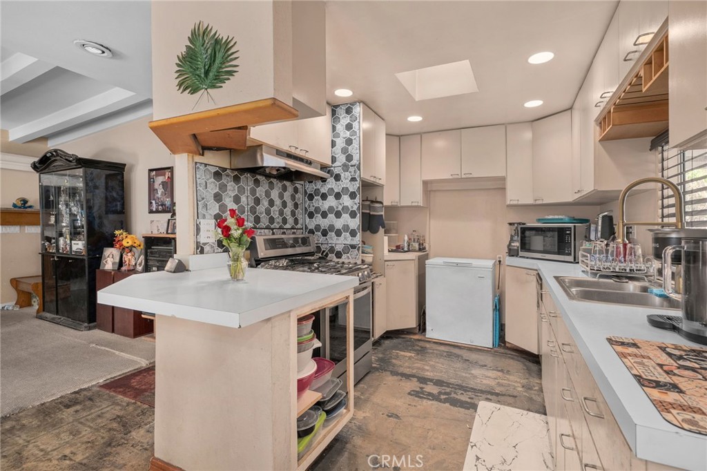 6757 Clifford Street Riverside, CA 92504 - Photo 5 of 25 a kitchen that has a lot of white cabinets and stainless steel appliances
