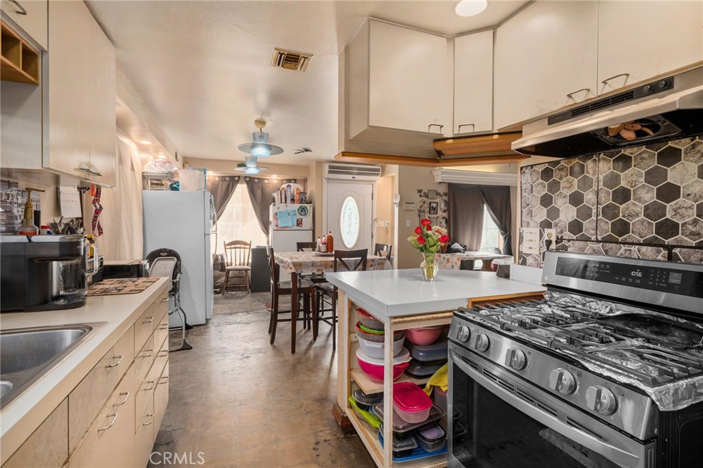 6757 Clifford Street Riverside, CA 92504 - Photo 6 of 25 a kitchen with stainless steel appliances granite countertop a stove and a view of living room