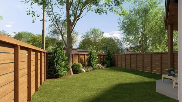 a view of backyard with potted plants and large tree