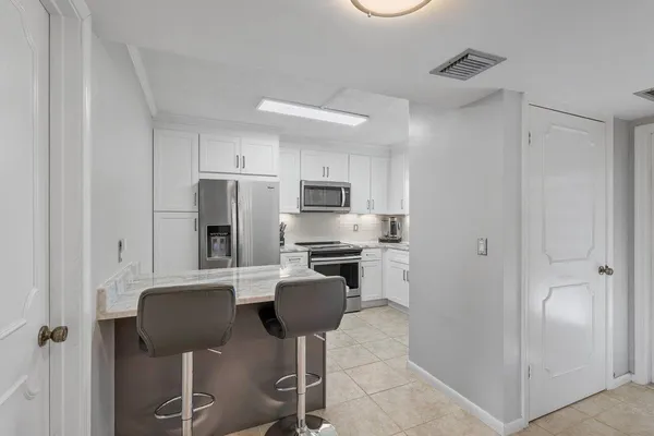 a kitchen with stainless steel appliances granite countertop a refrigerator and a stove top oven