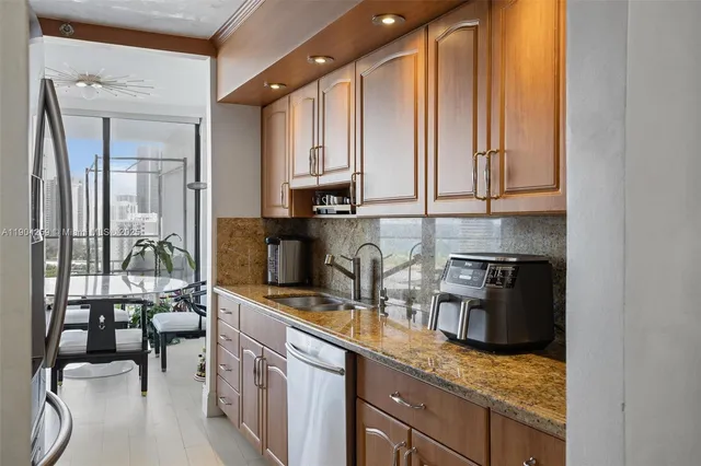 a kitchen with stainless steel appliances granite countertop a sink stove and refrigerator