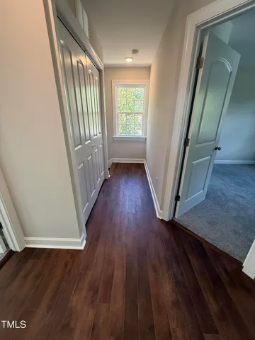 a view of a hallway with wooden floor and staircase