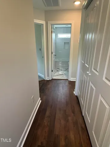 a view of a hallway with wooden floor
