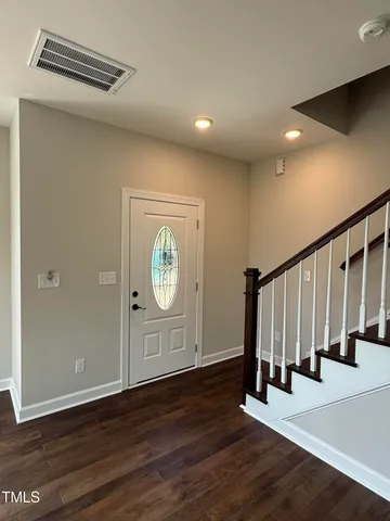 a view of a hallway with wooden floor and entryway