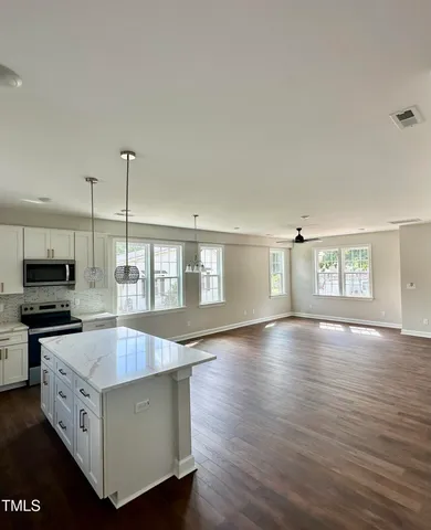 a kitchen with stainless steel appliances granite countertop a stove and a wooden floors