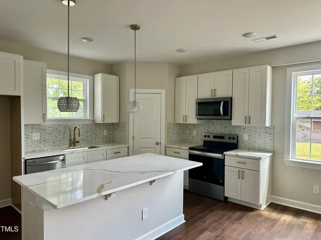 a kitchen with stainless steel appliances granite countertop a sink stove and refrigerator