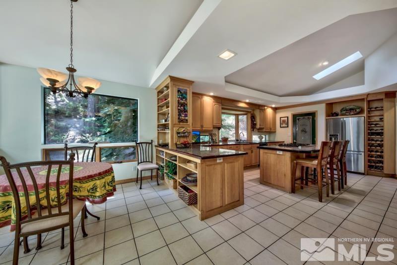 369 Summit Drive Stateline, NV 89449 - Photo 11 of 39 a kitchen with stainless steel appliances kitchen island granite countertop a table chairs and a view of living room