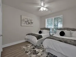 a living room with two bed and a window