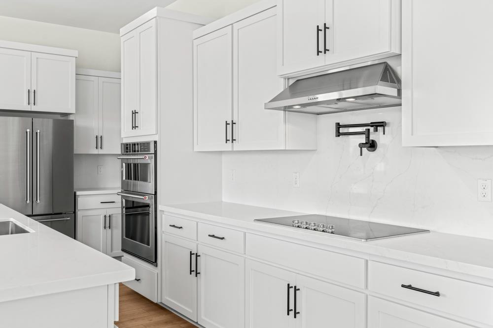 7058 Sheldon Rnch Drive Rancho Murieta, CA 95683 - Photo 6 of 26 a kitchen with stainless steel appliances white cabinets and a refrigerator