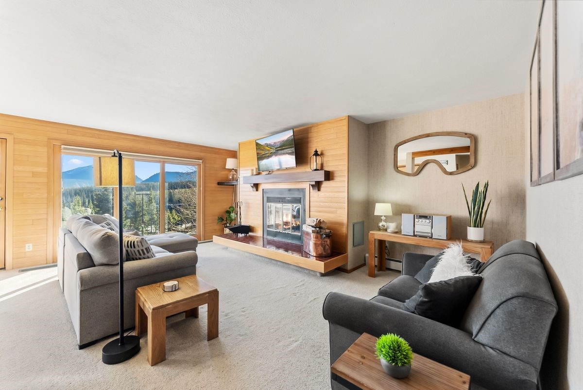 91300 Ryan Gulch Road, Unit 91311 Silverthorne, CO 80498 - Photo 15 of 29 a living room with furniture fireplace and a large window