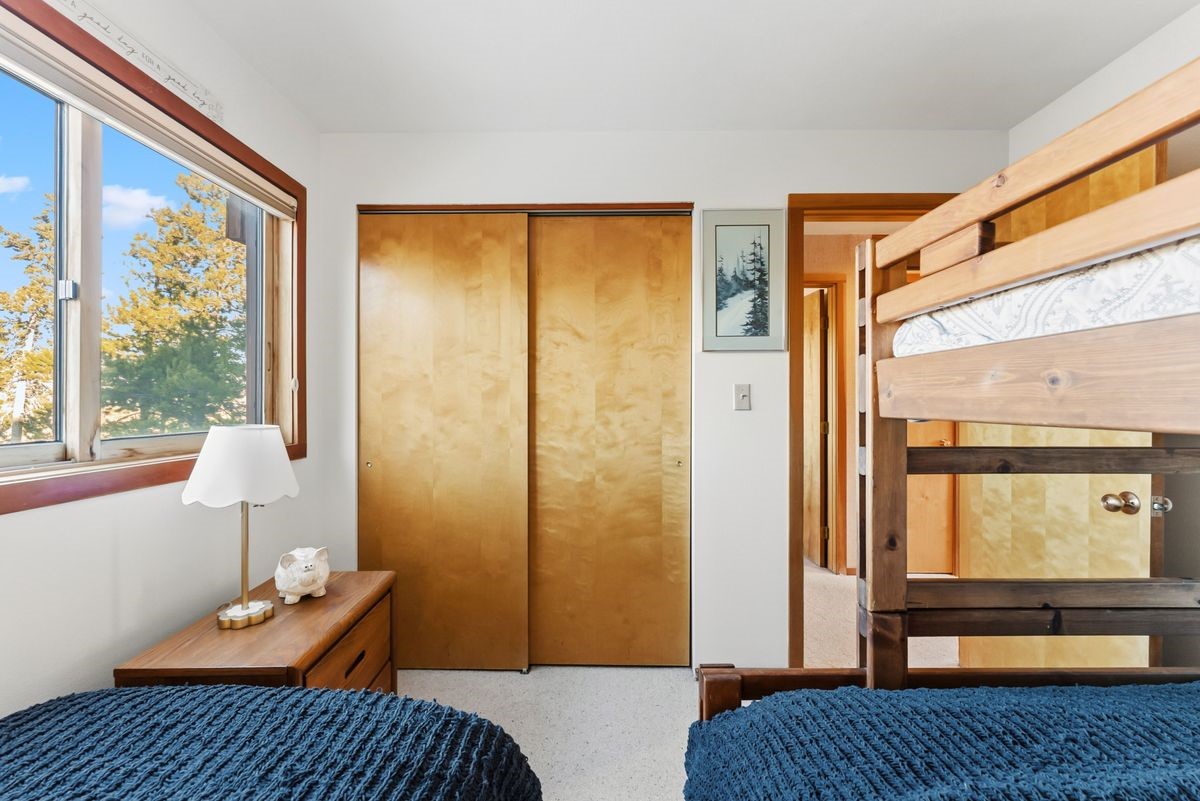 91300 Ryan Gulch Road, Unit 91311 Silverthorne, CO 80498 - Photo 18 of 29 a bedroom with a bed and wooden floor