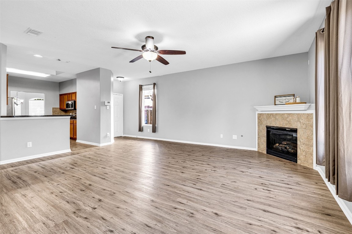 5026 Forest Hurst Drive Spring, TX 77373 - Photo 8 of 31 a view of a livingroom with a fireplace a ceiling fan and wooden floor