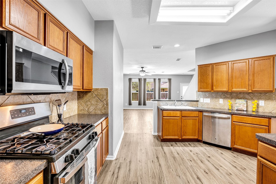 5026 Forest Hurst Drive Spring, TX 77373 - Photo 10 of 31 a kitchen with stainless steel appliances granite countertop hardwood floor sink stove and granite counter top