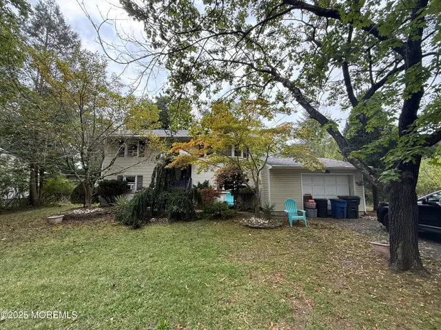 a view of a house with a yard and tree s