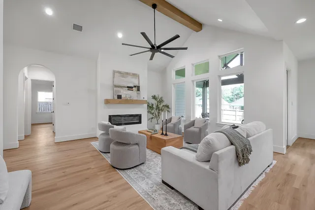 a living room with furniture a fireplace and a chandelier
