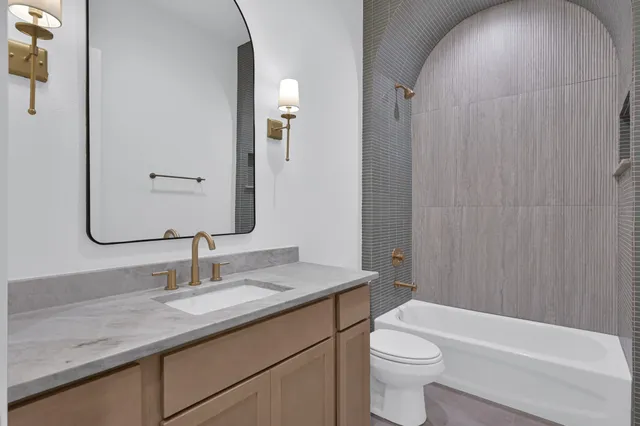 a bathroom with a granite countertop sink toilet and shower