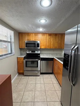 a kitchen with stainless steel appliances granite countertop a refrigerator a stove and a sink