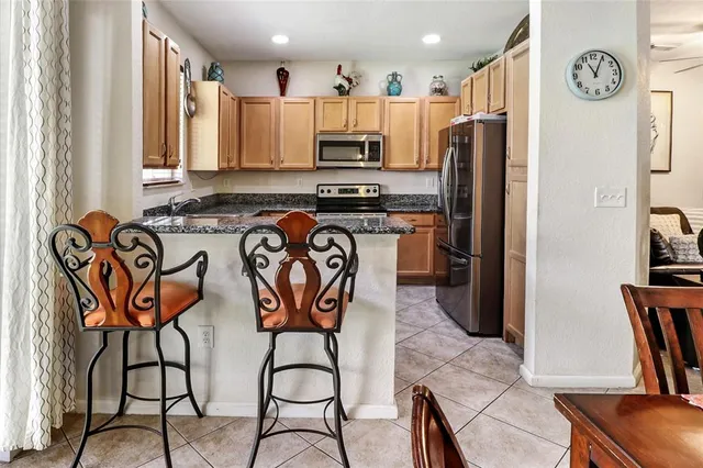 a kitchen with stainless steel appliances granite countertop a refrigerator and a stove top oven
