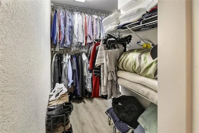 a view of walk in closet with clothes and shoes