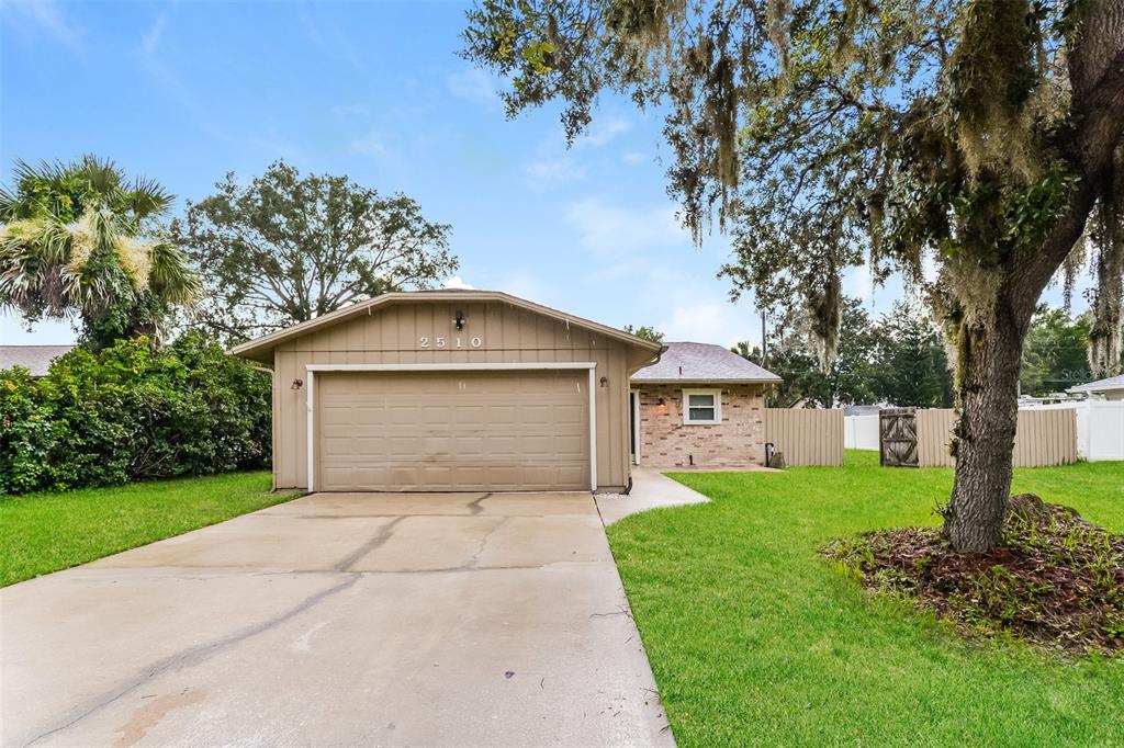 a front view of a house with yard and trees