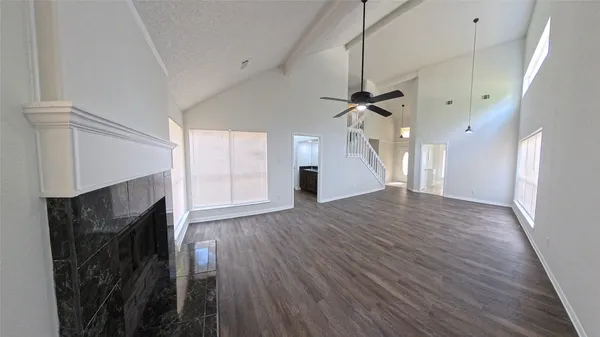 a view of a livingroom with wooden floor and a ceiling fan