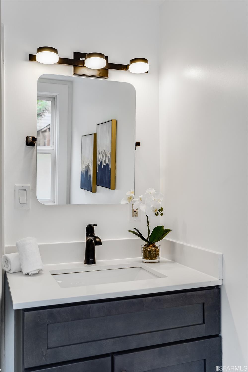1366 34th Street Oakland, CA 94608 - Photo 49 of 51 a bathroom with a sink a mirror and vanity