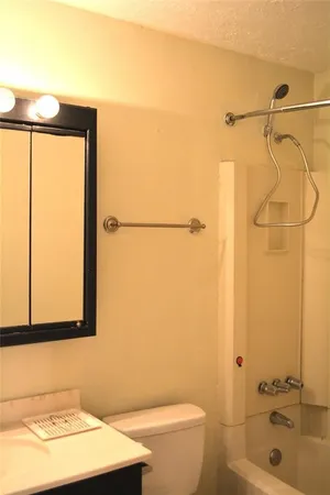 a bathroom with a granite countertop sink toilet and shower