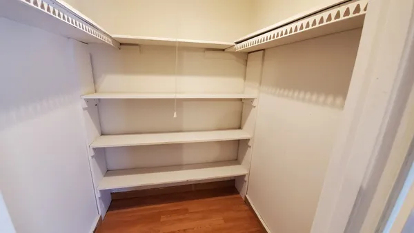 a view of walk in closet with empty racks
