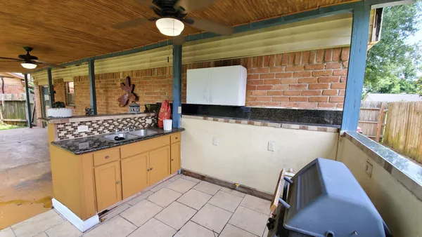 a view of a chair and table in backyard of the house