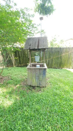 a view of a chair and table in backyard of the house