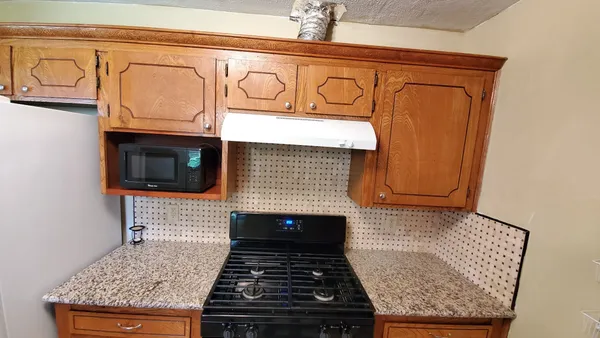 a stove top oven sitting inside of a kitchen