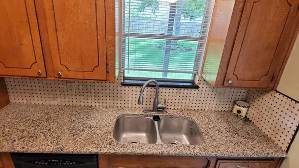 a kitchen with granite countertop sink and cabinets