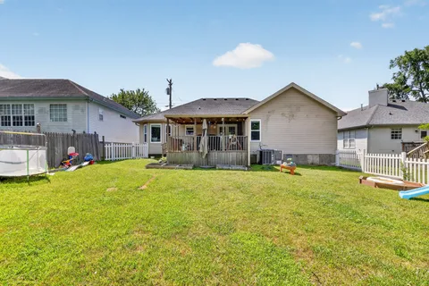a front view of a house with a yard and trees