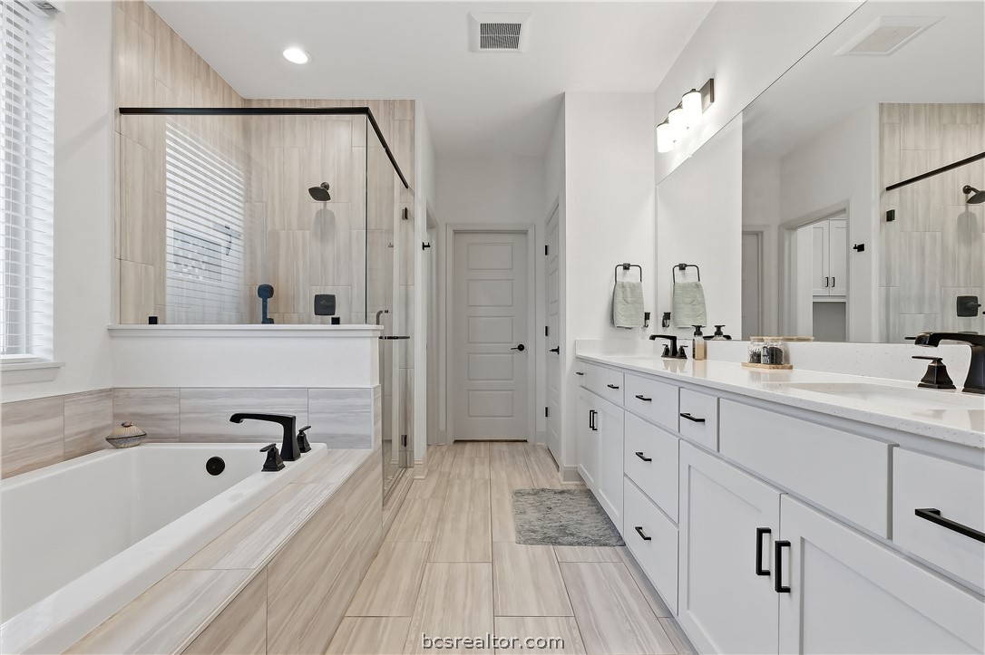 3500 Castine Court Bryan, TX 77808 - Photo 23 of 46 Primary bath with garden tub, 2 sinks, quartz counters, tiled shower and toilet closet
