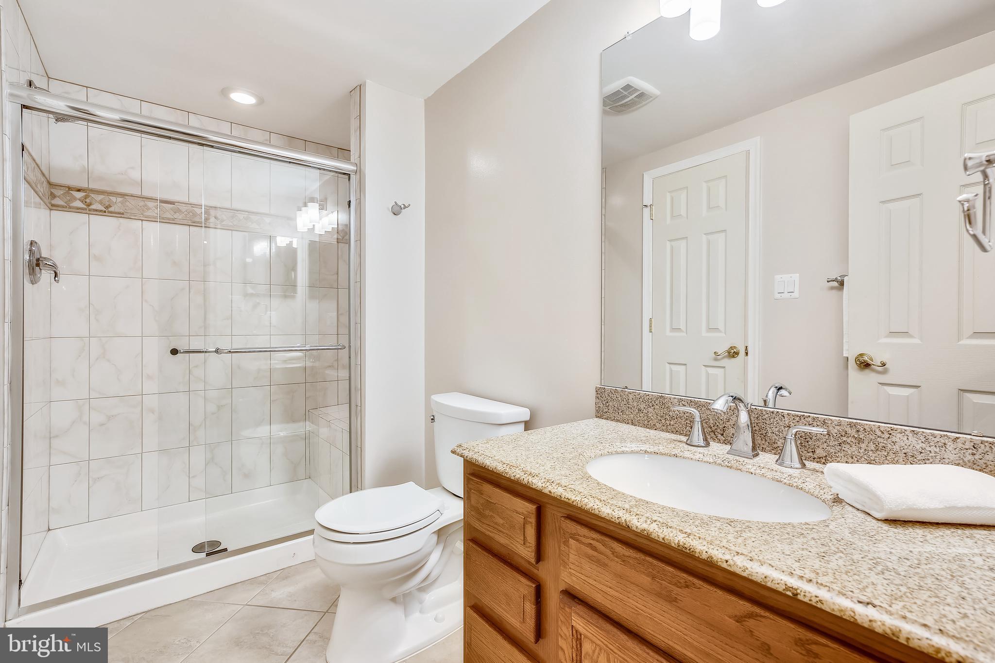 1593 Kimblewick Road Potomac, MD 20854 - Photo 38 of 45 a bathroom with a granite countertop sink toilet and shower