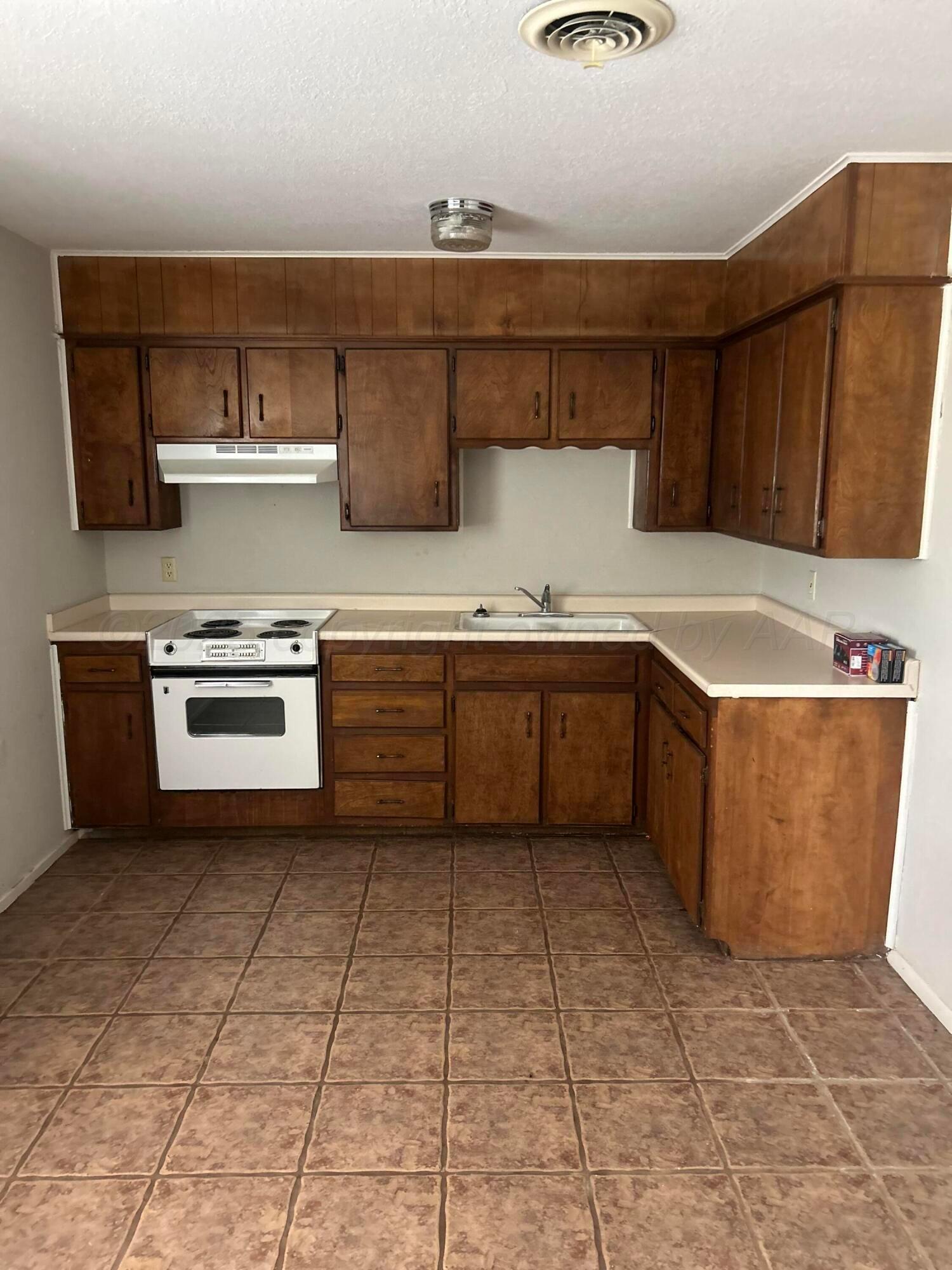 401 Mesa View Miami, TX 79059 - Photo 3 of 11 a kitchen with stainless steel appliances granite countertop a sink and cabinets