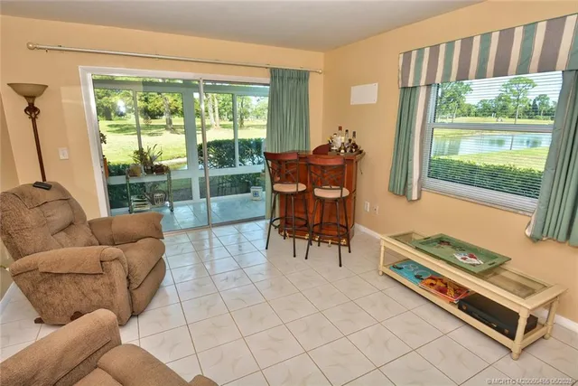 a living room with furniture and a floor to ceiling window