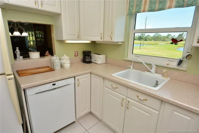 a kitchen with white cabinets and a sink