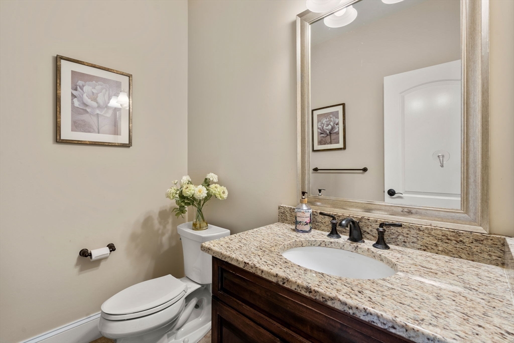 50 Sterling Road Needham, MA 02492 - Photo 11 of 29 a bathroom with a granite countertop toilet a sink and a mirror