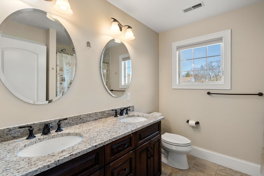 50 Sterling Road Needham, MA 02492 - Photo 16 of 29 a bathroom with a granite countertop toilet a sink and a mirror