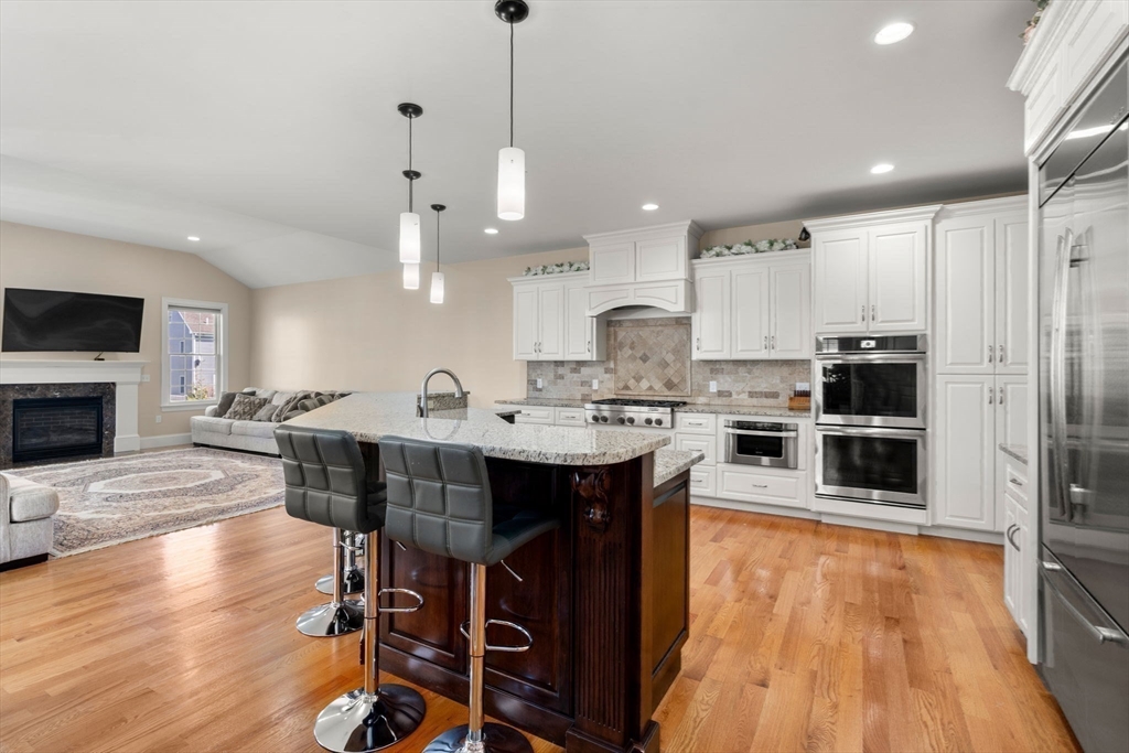 50 Sterling Road Needham, MA 02492 - Photo 6 of 29 a open kitchen with stainless steel appliances kitchen island granite countertop a table chairs and a refrigerator