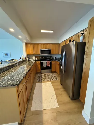 a kitchen with stainless steel appliances granite countertop a refrigerator and a sink