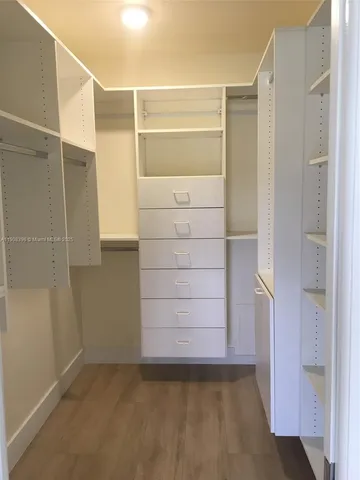 a view of walk in closet with empty racks