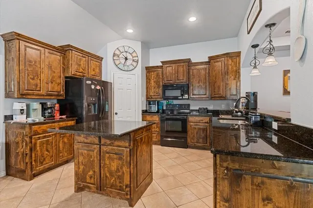 a kitchen with stainless steel appliances granite countertop a refrigerator a stove top oven a sink and dishwasher