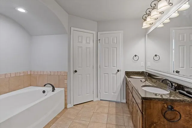 a bathroom with a tub sink and mirror